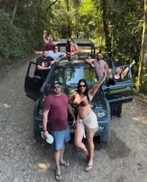 Grupo de amigos posando na caminhonete na estrada de terra