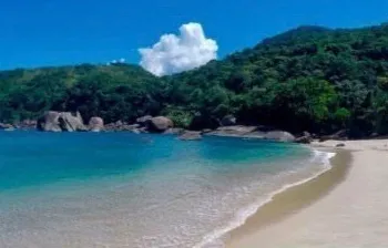 Praia de Indaiaúba com areia clara e pedras