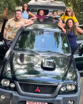 Grupo acenando em pé na caçamba da caminhonete